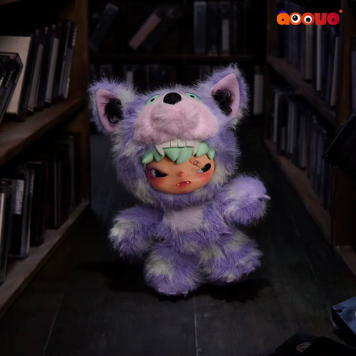 A purple furry monster doll with a human face peeking out from its mouth, standing in a dark bookshelf aisle.